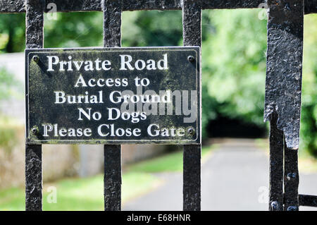 Auf dem Tor auf einen Friedhof zu unterzeichnen: "Private Straße.  Zugang zum Friedhof. Keine Hunde. Bitte schließen Sie Tor " Stockfoto