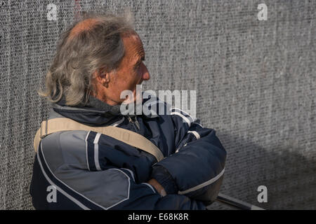 Ein alte italienische Mann sitzt und Uhren Touristen durch den Markusplatz in Venedig. Stockfoto