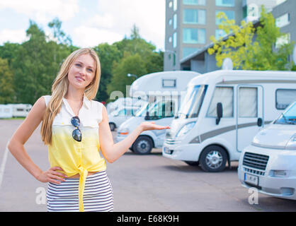 Schöne junge Frau bietet Wohnmobile im Shop. Stockfoto