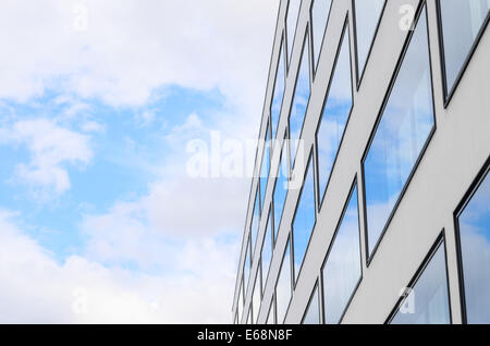 Blauer Himmel und Wolken reflektiert in gespiegelten Fenstern des neuen, modernen Gebäude Glasfassade. Hintergrund mit Kopie-Freiraum für Stockfoto