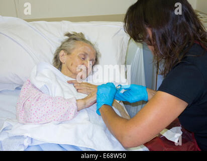 Älteren Patienten in ihre neunziger Jahre Nägel schneiden von Verwandten im NHS Krankenhaus Krebs diagnostiziert. England. UK Stockfoto