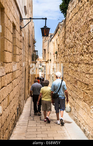 Touristen, die entlang eines mittelalterlichen Gassen von Mdina, Mdina, Malta. Stockfoto