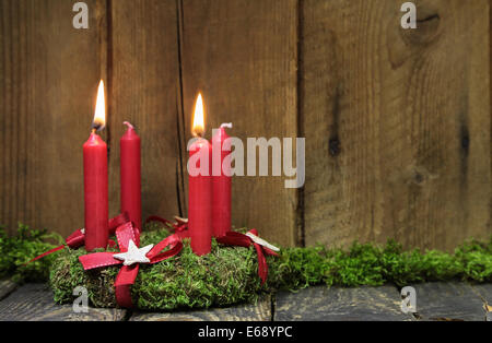 Advent oder Weihnachten Kranz mit vier roten Kerzen auf hölzernen Hintergrund. Stockfoto