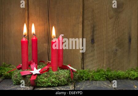 Advent oder Weihnachten Kranz mit vier roten Kerzen auf hölzernen Hintergrund. Stockfoto