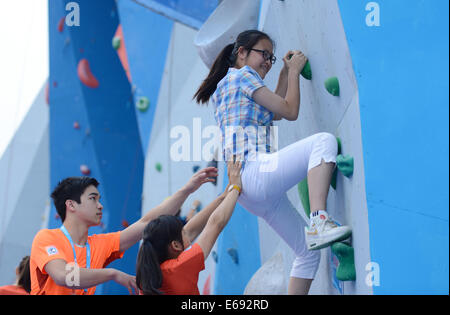 (140819)--NANJING, Aug 19,2014 (Xinhua)--Liu Qinchang, Schüler von Nanjing Xincheng Mittelschule Erfahrungen Sportklettern am Sports Lab in der Nanjing 2014 die Olympischen Jugendspiele in Nanjing, Hauptstadt der ostchinesischen Provinz Jiangsu, 19. August 2014. Inline Skates entlang mit Wushu, Sportklettern und Skateboarding, werden für die Präsentation in der Sports Lab vom 17. August bis 27. August ausgewählt. Mehr als 2000 Zuschauer kommen, Sports Lab am Dienstag zu erleben. (Xinhua/Zhang Hongxiang) Stockfoto