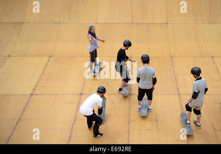 (140819)--NANJING, 19. August 2014 (Xinhua)--Amerikas Skateboard Spieler Lizzie Armanto (bis L) betreut die Studierenden von Nanjing Xincheng Middle School Sports Lab in der Nanjing 2014 die Olympischen Jugendspiele in Nanjing, der Hauptstadt der ostchinesischen Provinz Jiangsu, 19. August 2014. Inline Skates entlang mit Wushu, Sportklettern und Skateboarding, werden für die Präsentation in der Sports Lab vom 17. August bis 27. August ausgewählt. Mehr als 2000 Zuschauer kommen, Sports Lab am Dienstag zu erleben. (Xinhua/Zhang Hongxiang) Stockfoto