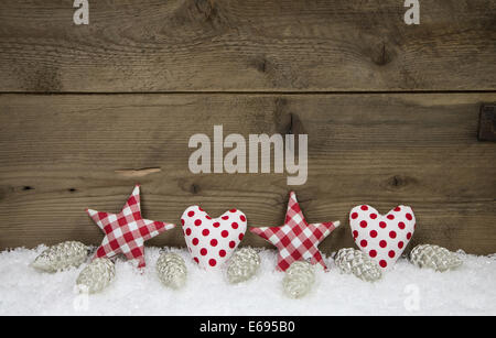 Aus Holz Weihnachten Hintergrund mit rot weiß überprüft, Herzen und Sterne auf Schnee. Stockfoto