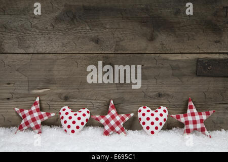 Aus Holz Weihnachten Hintergrund mit rot weiß überprüft, Herzen und Sterne auf Schnee. Stockfoto