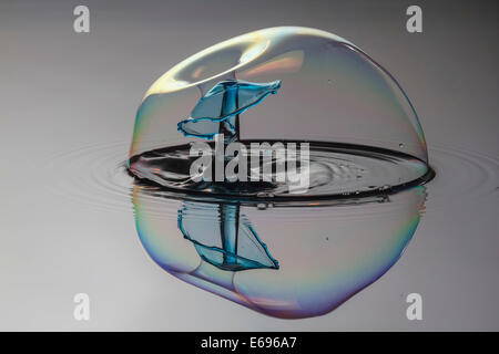 Drei Tropfen kollidieren, der erste bildet eine Spalte, die zweite erzeugt das Schild, gefolgt von der dritten, digital gesteuert mit Stockfoto