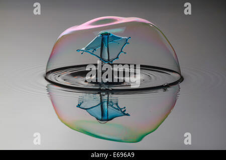 Drei Tropfen kollidieren, der erste bildet eine Spalte, die zweite erzeugt das Schild, gefolgt von der dritten, digital gesteuert mit Stockfoto