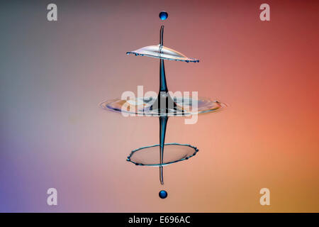 Drei Tropfen kollidieren, der erste bildet eine Spalte, die zweite erzeugt das Schild, gefolgt von der dritten, digital gesteuert mit Stockfoto