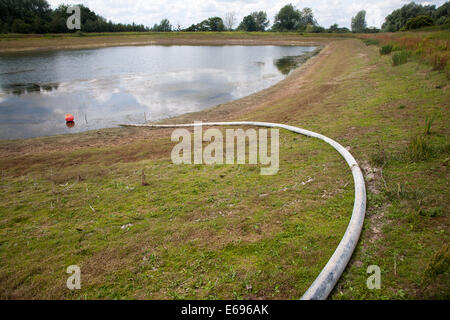 Bewässerung Rohr Wasser Stausee auf niedrigem Niveau im Sommer Sutton, Suffolk, England Stockfoto