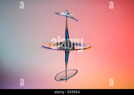 Drei Tropfen kollidieren, der erste bildet eine Spalte, die zweite erzeugt das Schild, gefolgt von der dritten, digital gesteuert mit Stockfoto