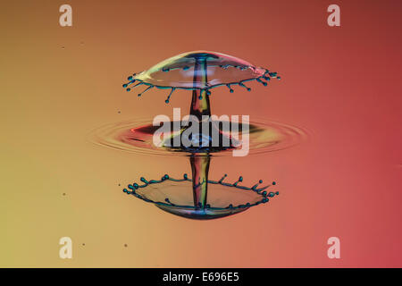 Drei Tropfen kollidieren, der erste bildet eine Spalte, die zweite erzeugt das Schild, gefolgt von der dritten, digital gesteuert mit Stockfoto