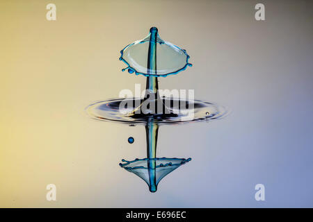 Drei Tropfen kollidieren, der erste bildet eine Spalte, die zweite erzeugt das Schild, gefolgt von der dritten, digital gesteuert mit Stockfoto