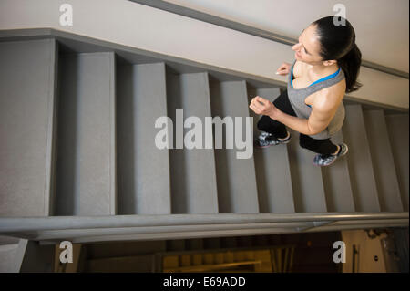 Kaukasische Frau, die Treppe hinauf läuft Stockfoto