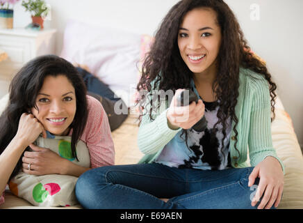 Mutter und Tochter vor dem Fernseher auf Bett Stockfoto