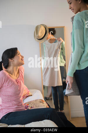 Mutter hilft der Tochter Kleid zu wählen Stockfoto