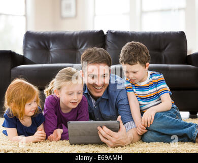 Kaukasische Vater und Kindern bei der Nutzung von Tablet-PC im Wohnzimmer Stockfoto