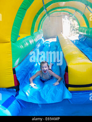 Kaukasische Mädchen lachend auf Wasserrutsche Stockfoto