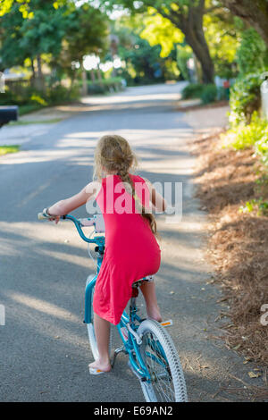 Kaukasische Mädchen Reiten Fahrrad auf Straße Stockfoto