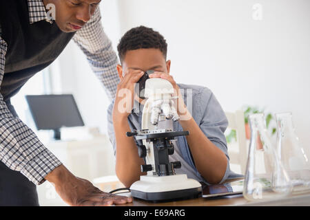 Lehrer helfen Schüler Verwendung Mikroskop im naturwissenschaftlichen Unterricht Stockfoto