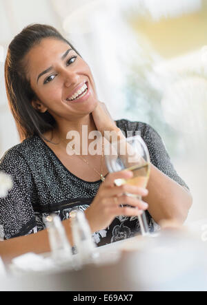 Hispanic Frau trinkt Wein beim Abendessen Stockfoto