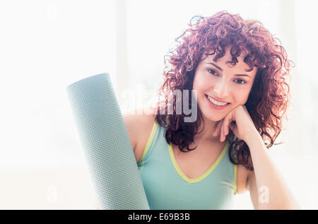 Hispanic Frau mit Yoga-Matte Stockfoto