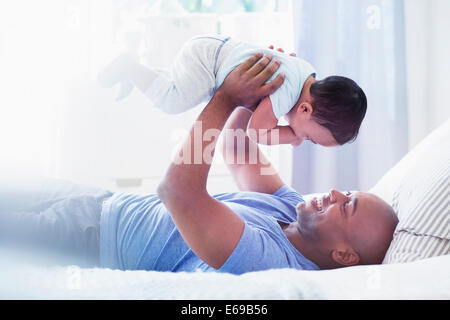 Vater, spielen mit Baby auf Bett Stockfoto