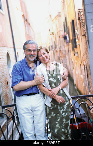 Älteres paar umarmt über städtischen Kanal, Venedig, Veneto, Italien Stockfoto