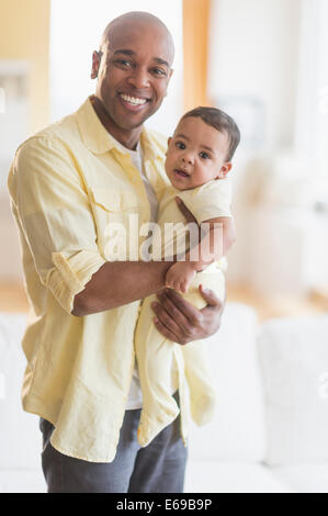 Lächelnd hält Baby Vater Stockfoto