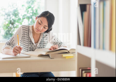 Gemischte Rassen Teenager-Mädchen studieren in Bibliothek Stockfoto