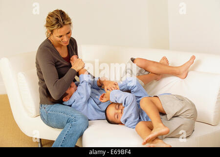 Mutter und Kinder spielen am sofa Stockfoto