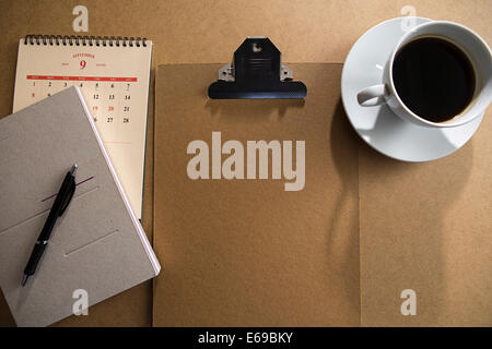 Zwischenablage und Notizblock mit Kaffee am Tisch Stockfoto