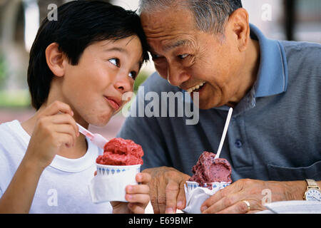 Ältere Mann und Enkel essen Eis im freien Stockfoto
