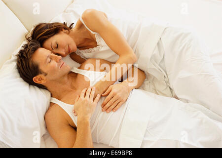 Paar im Bett umarmt Stockfoto