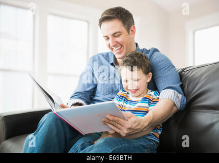 Kaukasische Vater und Sohn auf dem Sofa lesen Stockfoto