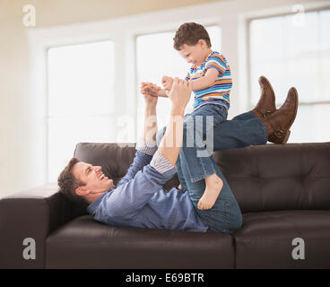 Kaukasische Vater und Sohn spielen auf sofa Stockfoto