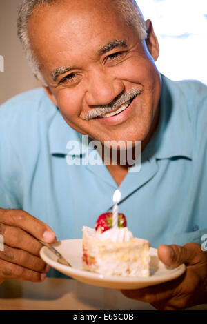 Ältere Menschen essen Geburtstagskuchen Stockfoto