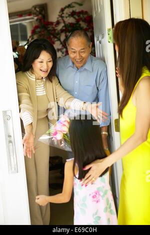 Älteres paar Gruß Enkelin an Tür Stockfoto