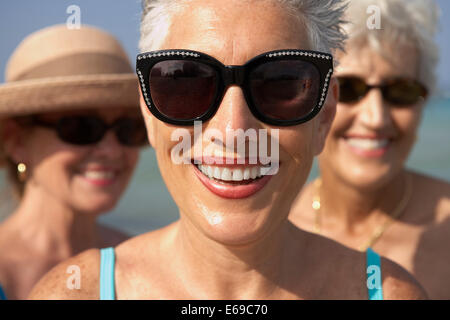 Ältere Frau mit Sonnenbrille am Strand Stockfoto