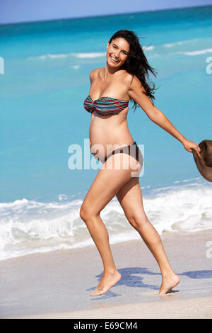 Hispanic Schwangere zu Fuß am Strand Stockfoto