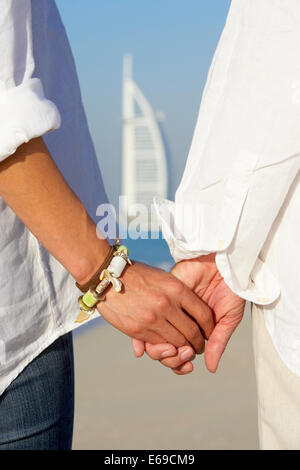 Paar halten die Hände auf Strand, Dubai, Vereinigte Arabische Emirate Stockfoto