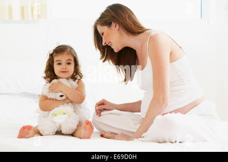Kaukasische Mutter und Tochter spielen mit Teddybär Stockfoto