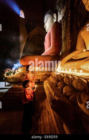 Asiatische Mutter und Tochter Anzünden von Kerzen im Tempel Stockfoto