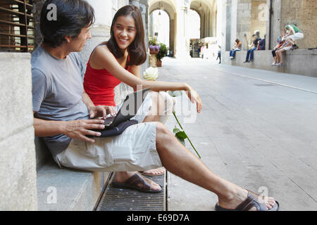 Paar mit Laptop auf Stadtstraße Stockfoto