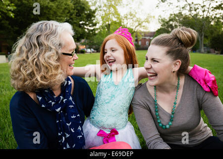 Drei Generationen der kaukasischen Frauen sitzen im park Stockfoto