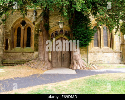 Pfarrkirche St. Edward Nordtür flankiert von Eiben, Stow-on-the-Wold, Gloucestershire, UK Stockfoto