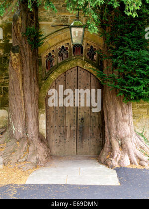 Pfarrkirche St. Edward Nordtür flankiert von Eiben, Stow-on-the-Wold, Gloucestershire, UK Stockfoto