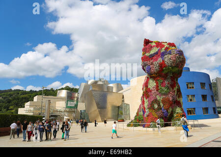 BILBAO, Spanien - 10. Juli 2014: Unbekannte Personen in der Nähe der Blume Welpe vor dem Guggenheim-Museum. Stockfoto